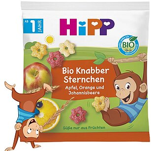 Obal na bio ovocné svačinky s ilustrací opice, s motivy jablka, pomeranče a skokana, s bio certifikací a etiketou v německém jazyce.