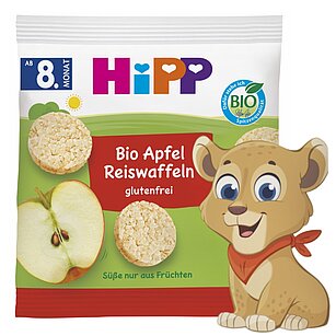 Balený potravinářský výrobek s maskotem lva a grafikou jablka.