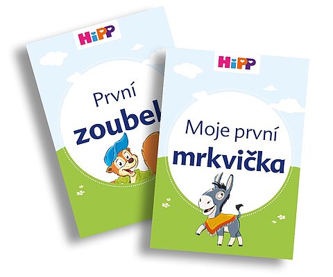 Dvě obálky dětských knih s veverkou a oslíkem, s názvy "Prvni zoubel" a "Moje prvni mrkvicka" v češtině.