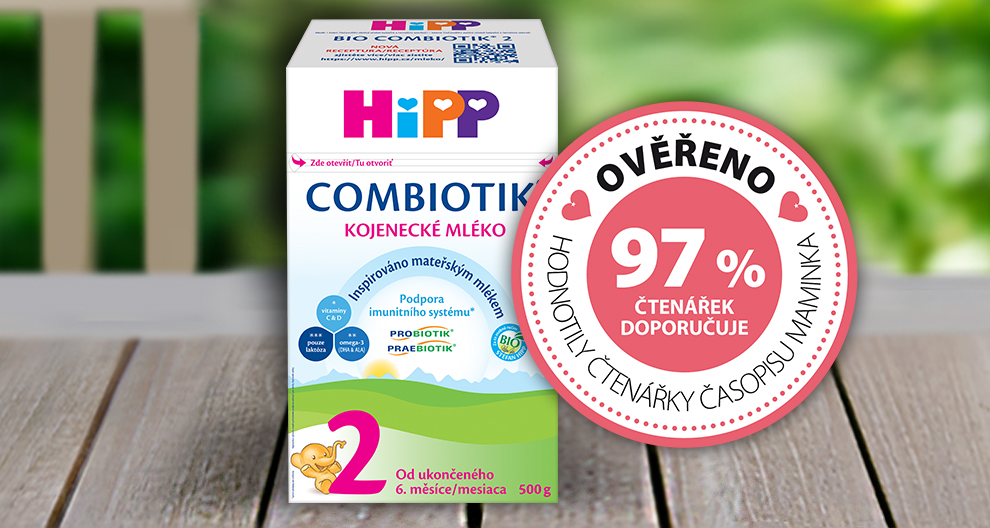 Na dřevěné ploše je umístěna krabice výrobku s nápisem "HiPP COMBIOTIK KOJENCKE MLEKO" s ilustrací dítěte a údajem o hmotnosti 500 g, doplněná kruhovým štítkem s nápisem "97% HODNOTILY ČTENÁREK DOPORUCUE" v růžovém odstínu.