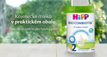 Nádobka s kojeneckou výživou Hipp Bio Combiotik, 2. stupeň, je umístěna na dřevěném podkladu s rozmazaným pozadím zeleně.