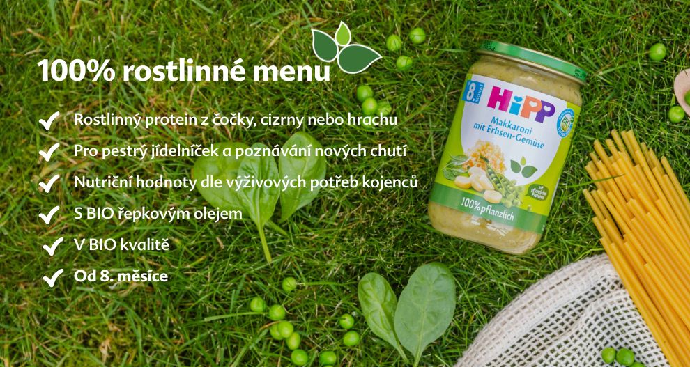 Na travnaté ploše je položena sklenice s dětskou výživou, obklopená čerstvou zeleninou a síťovým sáčkem, vlevo od ní je seznam funkcí v cizím jazyce.