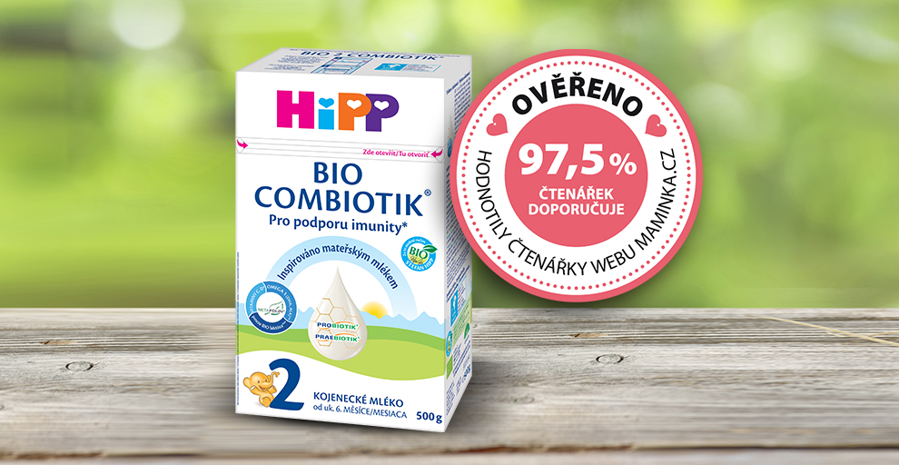 Krabice kojenecké výživy Hipp Bio Combiotik, 2. stupeň, s odznakem 97,5% spokojenosti, umístěná na dřevěném podkladu s rozmazaným zeleným pozadím.