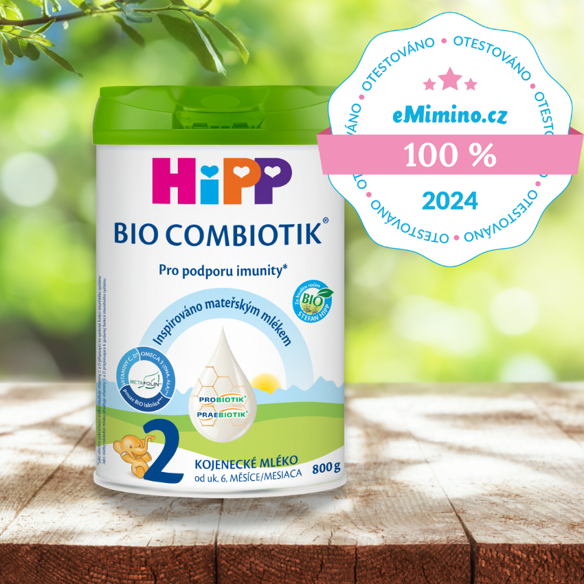 Nádobka kojenecké výživy Hipp Bio Combiotik, 2. stupeň, se 100% hodnocením od eMimino.cz pro rok 2024, zobrazená na dřevěném podkladu s rozmazaným zeleným pozadím.